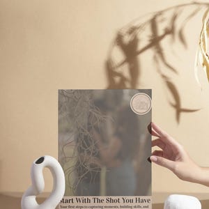 May include: A book titled Start With The Shot You Have, featuring the subtitle Your first steps to capturing moments, building skills, and believing in yourself, written by Dalila Lee, with a circular camera icon on the cover.