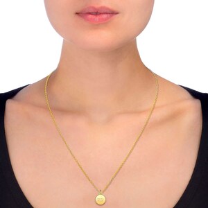 May include: A gold chain necklace with a small round pendant that says "One in a Million".