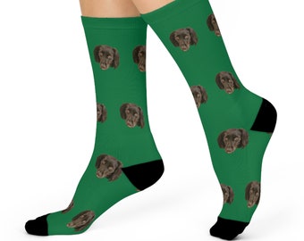 May include: A pair of green socks with a repeating pattern of a brown dog's face.