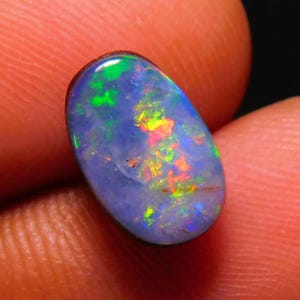 May include: A blue oval opal gemstone with flashes of green, yellow, and red.