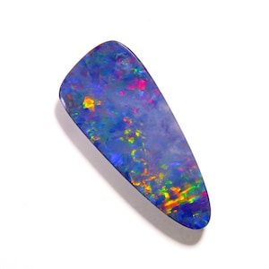 May include: A polished, teardrop-shaped black opal gemstone featuring a deep blue base color with vibrant, multi-colored flashes of green, yellow, and red light reflecting across its smooth, iridescent surface against a plain white background.