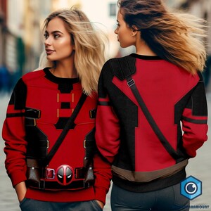 May include: Two people wearing red and black sweatshirts with a Deadpool design. The sweatshirts feature a black strap across the chest and a belt with a Deadpool logo.