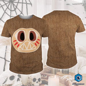 a brown t-shirt with a large, cartoonish face design on it. The t-shirt is displayed in two different views, with the front view showing the design and the back view showing the back of the shirt.