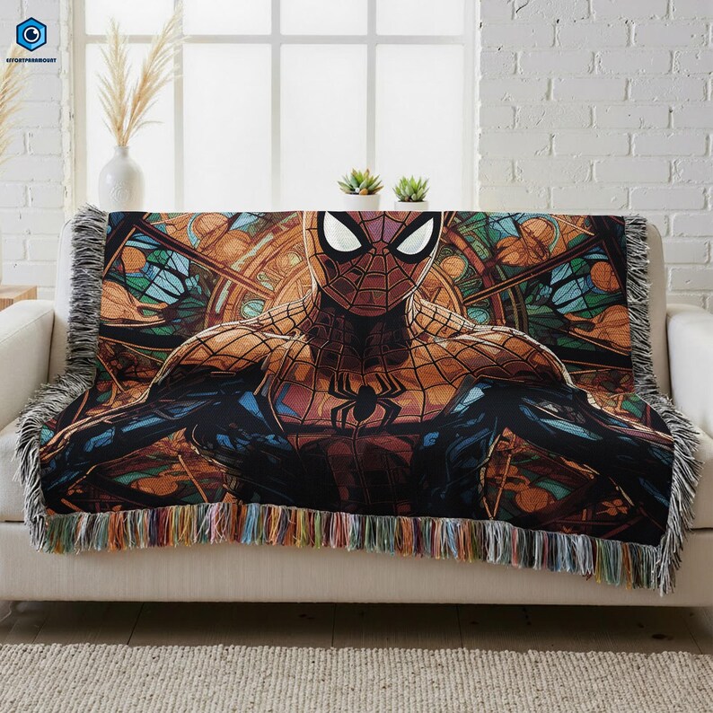 A colorful, patterned blanket featuring a Spiderman character is draped over a white couch.