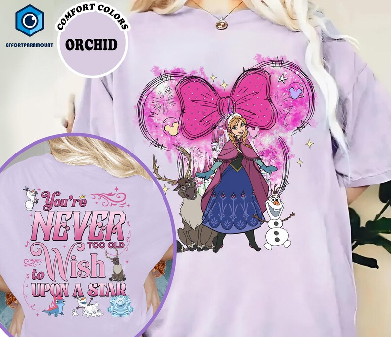 A t-shirt with a cartoon image of a girl surrounded by various characters, including a reindeer and a snowman. The text on the t-shirt says "You're never too old to wish upon a stair".