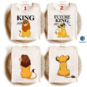 May include: A white ceramic mug with a black handle and the text "But First, Coffee" in a black, handwritten-style font. The mug is on a white surface.