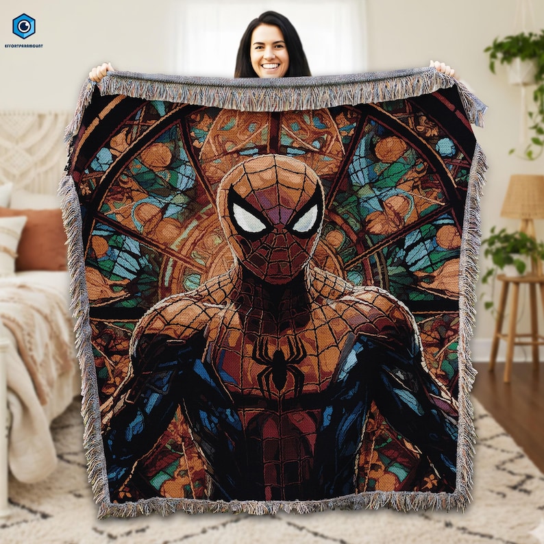 A woman is holding up a large, colorful tapestry featuring a Spiderman character.