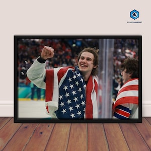 May include: A framed photograph featuring a celebratory moment. A person is wrapped in an American flag, with a joyful expression and raised fist. Another person is partially visible, also draped in a flag.