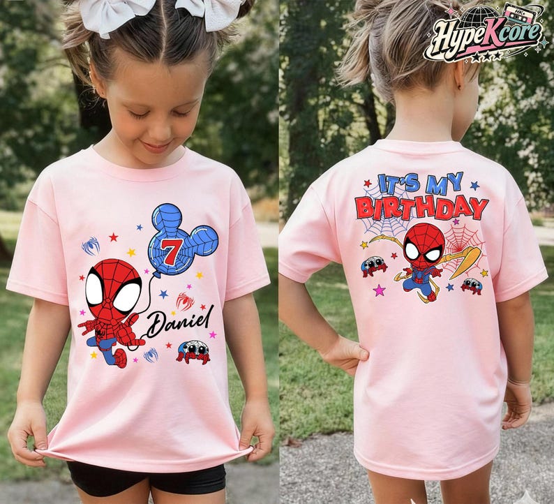 May include: Pink t-shirt featuring a cartoon Spider-Man design. The front of the shirt has a Spider-Man graphic, a balloon with the number 7, and the name "Daniel". The back of the shirt says "It's My Birthday" with a Spider-Man graphic.