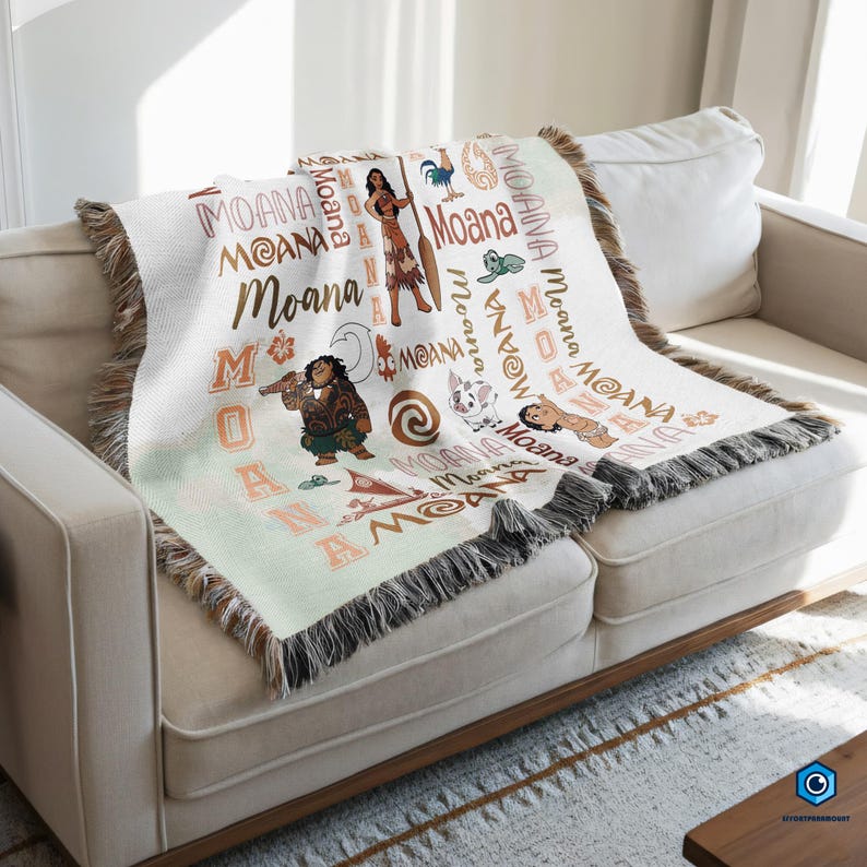 a cozy couch with a colorful throw blanket on it. The blanket is decorated with various Disney characters and the word "Moana" written on it.