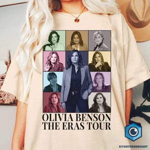 May include: A beige t-shirt with a collage of images of Olivia Benson from the TV show Law & Order: Special Victims Unit. The text "Olivia Benson The Eras Tour" is printed below the collage.