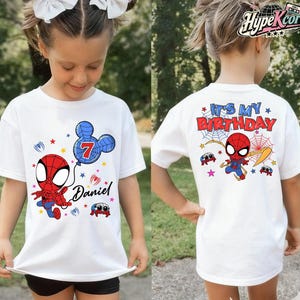 May include: White t-shirt featuring a cartoon Spider-Man design. The front of the shirt has a Spider-Man graphic, a blue balloon with the number 7, and the name "Daniel". The back of the shirt says "It's My Birthday" with Spider-Man graphics.