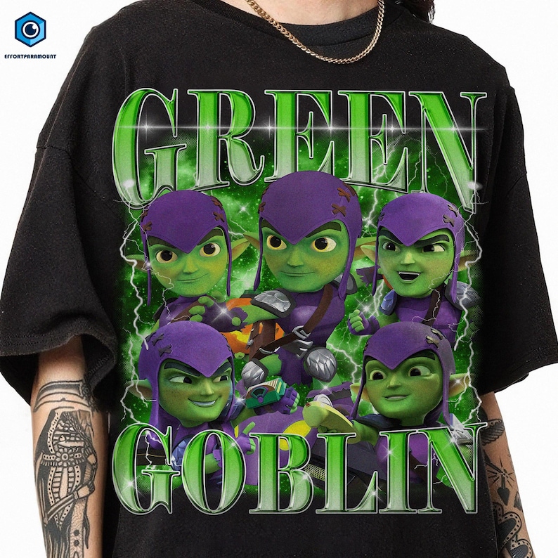 A black t-shirt with a graphic design featuring a group of green-skinned, purple-haired characters with the text "GREEN GOBLIN" prominently displayed.