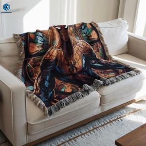 A colorful, patterned blanket featuring a Spiderman character is draped over a white couch.