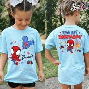 May include: Light blue t-shirts with a Spider-Man theme. The front of the shirt features a cartoon Spider-Man, a balloon with the number 7, and the name "Daniel". The back of the shirt says "It's My Birthday" with Spider-Man and spider web graphics.