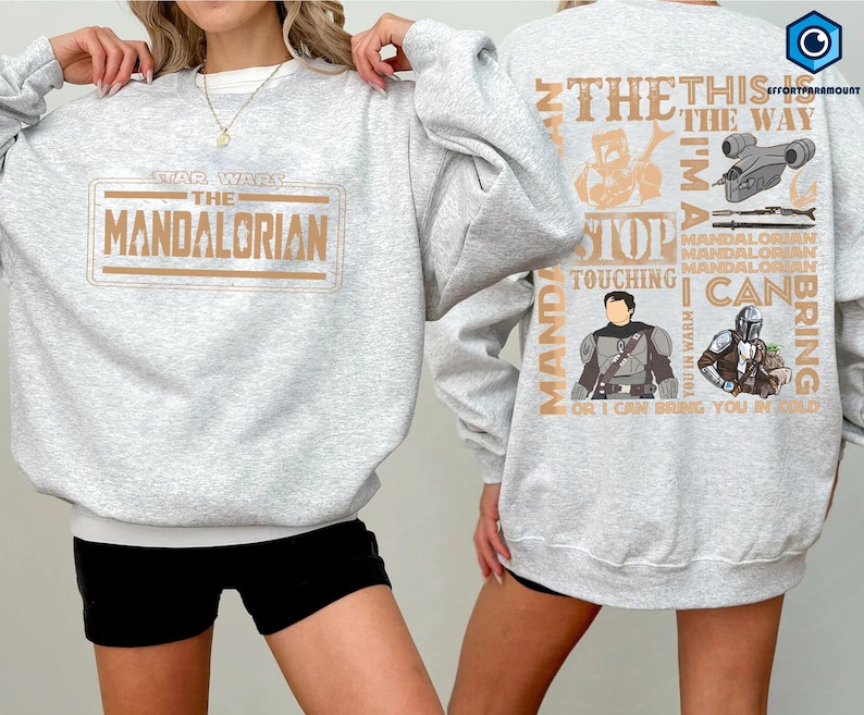 Puede incluir: Una sudadera gris claro con el texto "STAR WARS THE MANDALORIAN" en un dise&ntilde;o rectangular marr&oacute;n en la parte delantera. La parte trasera de la sudadera tiene un dise&ntilde;o con texto e im&aacute;genes relacionadas con la serie Mandalorian.