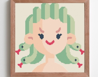May include: Cross-stitch art of Medusa with green hair and snakes, framed in a light brown wooden frame. The artwork features a light skin tone, a red smile, and dark blue eyes. The background is a light beige color.