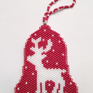 Könnte beinhalten: Roter und weißer Weihnachtsbaumschmuck in Form einer Glocke mit einem weißen Rentiermotiv.