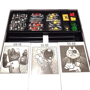 May include: A board game box with cards and game pieces. The cards feature cartoon illustrations and numbers, with the numbers 09-19, 31-42, and 55-66 visible. The game pieces are in red, yellow, and green. The box is black and white.
