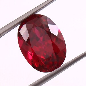 Peut inclure: Une pierre précieuse ovale de couleur rouge foncé avec une taille facetée.