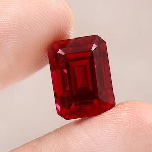 Puede incluir: Una piedra preciosa de color rojo intenso de talla esmeralda.