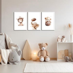 May include: Three framed watercolor illustrations of animals playing football. The illustrations are in a light brown color scheme and feature a giraffe, an elephant, and a bear.