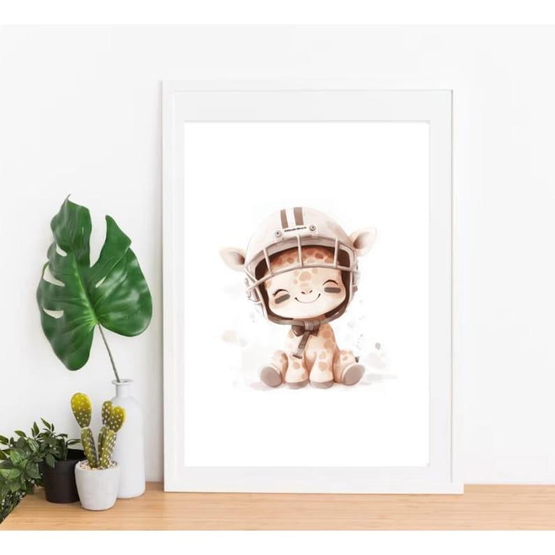 May include: A white framed print featuring a cartoon illustration of a giraffe wearing a brown and white football helmet. The giraffe is sitting on a white background with brown watercolor splatters.