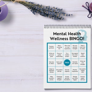 May include: A printable mental health wellness bingo card with a teal and white color scheme. The card features 25 squares with activities to promote mental well-being, such as practicing gratitude, taking a screening test, focusing on quality relationships, and spending time outdoors.