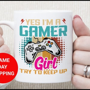 May include: White ceramic mug with a retro-style design featuring a video game controller and the text "Yes I'm a Gamer Girl Try to Keep Up".
