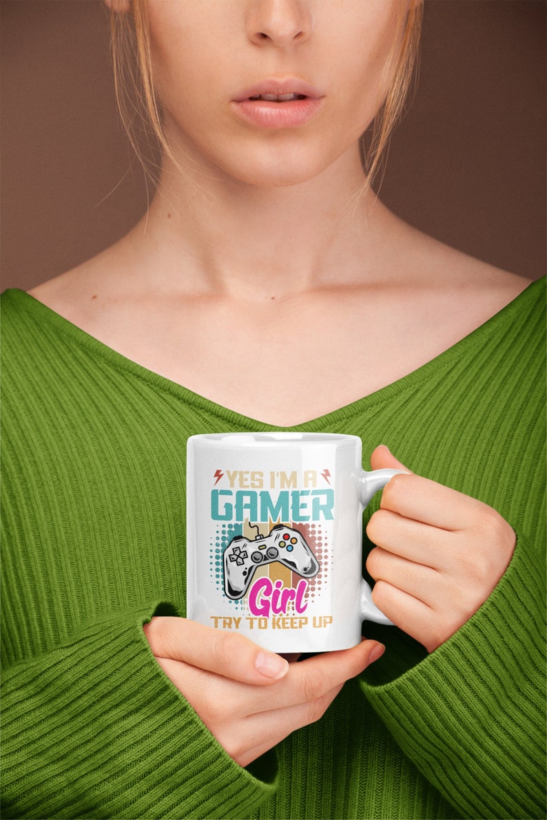 May include: White ceramic mug with a colorful graphic of a video game controller and the text "Yes I'm a Gamer Girl Try to Keep Up".