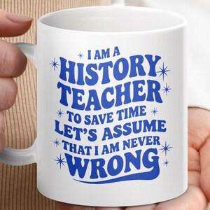 May include: White ceramic mug with the text "I AM A HISTORY TEACHER TO SAVE TIME LET'S ASSUME THAT I AM NEVER WRONG" in blue. The mug has a white handle and is held by a person.