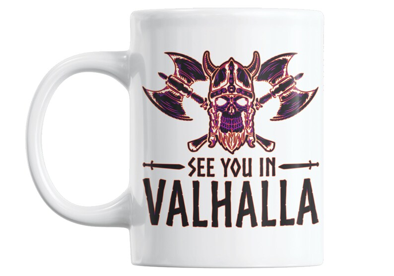 Puede incluir: Taza de cer&aacute;mica blanca con una ilustraci&oacute;n en negro y morado de una calavera con un casco con cuernos y hachas cruzadas. El texto "See you in Valhalla" est&aacute; impreso debajo de la ilustraci&oacute;n.