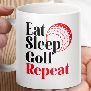 May include: White ceramic coffee mug with black text that reads "Eat Sleep Golf Repeat" and a red golf ball graphic.