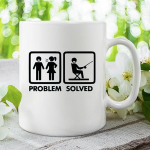 May include: White ceramic mug with a black graphic of a stick figure couple arguing and a stick figure man fishing with the text "Problem Solved".
