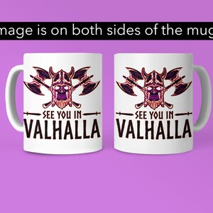 Puede incluir: Taza de cer&aacute;mica blanca con un gr&aacute;fico negro y morado de una calavera con un casco con cuernos y hachas cruzadas. El texto "See you in Valhalla" est&aacute; impreso debajo del gr&aacute;fico.