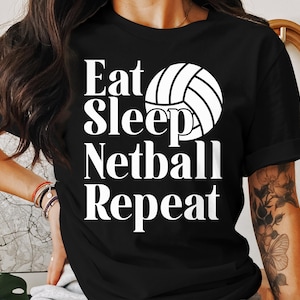 May include: Black t-shirt with white text that reads "Eat Sleep Netball Repeat" and a white netball graphic.