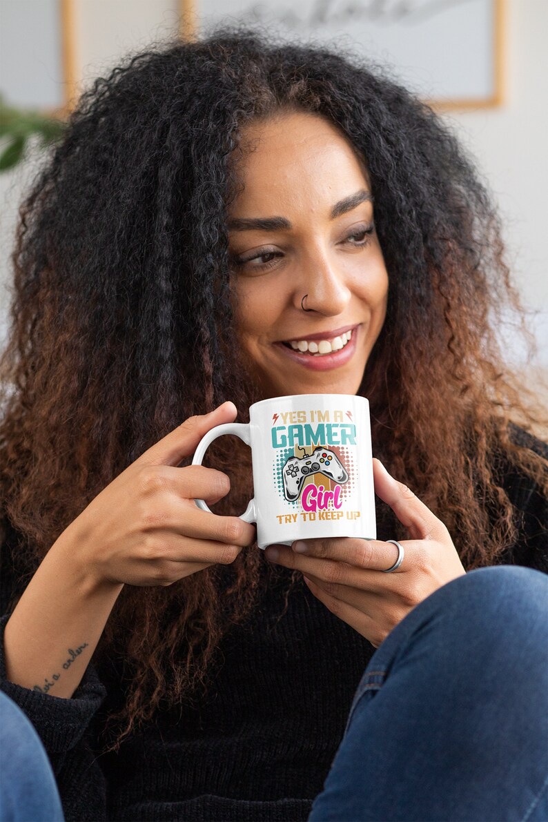 May include: White ceramic mug with a colorful design featuring a video game controller and the text "Yes I'm a Gamer Girl Try to Keep Up".