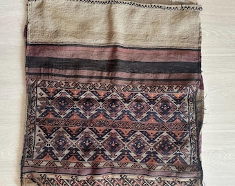 May include: A rectangular woven textile featuring a large section of beige fabric at the top, followed by horizontal stripes in black and dark red. The lower portion displays a complex geometric pattern of diamonds and chevrons in red, blue, and black.