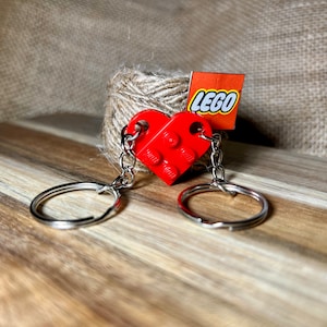 May include: Red Lego heart keychain with two silver key rings and a small red Lego tag that says "LEGO".