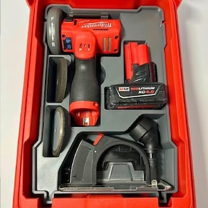 Peut inclure: Un ensemble d'outils électriques Milwaukee rouges dans un étui rouge. L'ensemble comprend une meuleuse rouge et noire, des batteries et des disques de coupe. L'étui est organisé avec des compartiments.
