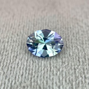K&ouml;nnte beinhalten: Ein ovaler Edelstein mit facettiertem Schliff. Der Edelstein hat eine hellblaue Farbe mit einem gr&uuml;nlichen Schimmer.