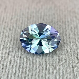 K&ouml;nnte beinhalten: Ein ovaler Edelstein mit facettiertem Schliff. Der Edelstein hat eine hellblaue Farbe mit einem gr&uuml;nlichen Schimmer.