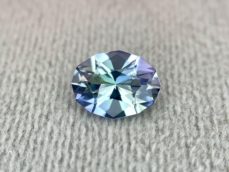 K&ouml;nnte beinhalten: Ein ovaler Edelstein mit facettiertem Schliff. Der Edelstein hat eine hellblaue Farbe mit einem gr&uuml;nlichen Schimmer.