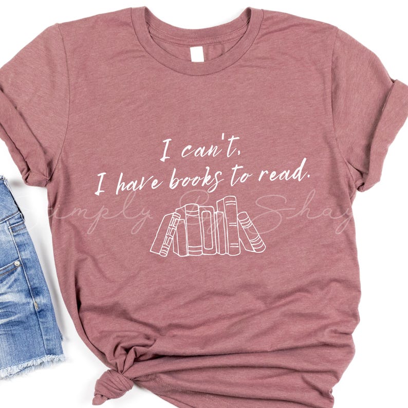 May include: A mauve t-shirt with the text "I can't, I have books to read." and a graphic of a stack of books.