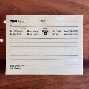 May include: A vintage TWA Memo notepad with a cream-coloured background. The notepad features the TWA logo, lines for writing, and checkboxes for actions like "Return" and "Approval". Printed in the USA.