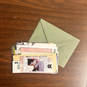 Puede incluir: Una pila de efímeras de papel de colores con una foto de dos personas en una casa. El papel incluye las palabras "Book House" y "card made".