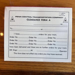 May include: A vintage Penn Central Transportation Company Clearance Form A. The form is white with black text and red borders. It includes fields for order numbers and other details, with the text "CLEARANCE FORM A" prominently displayed.