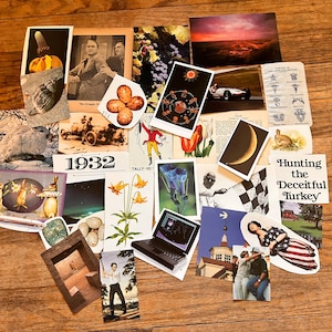 May include: A collection of vintage postcards and ephemera, including images of a car, a crescent moon, a turkey, a rabbit, a flower, a computer, and a building. The postcards are arranged on a wooden surface.