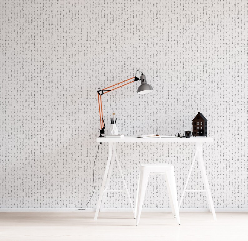 May include: A white desk with a white stool and a copper desk lamp. The desk is against a white wall with a black and white pattern. There is a small wooden house on the desk.
