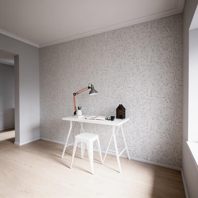 Pode incluir: Uma secret&aacute;ria branca com um banco branco a condizer, com um candeeiro de mesa com bra&ccedil;o cor de laranja, um pequeno objeto em forma de casa, uma caneca preta, um caderno e um porta-canetas, contra uma parede com papel de parede branco &agrave;s pintas.